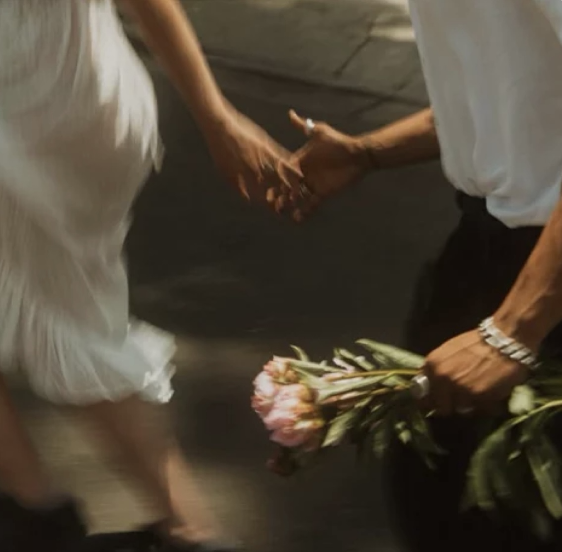 Holding hands, carrying a flower